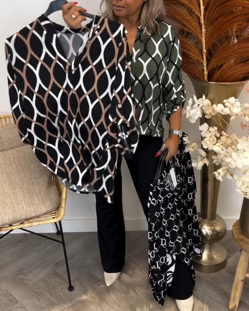 Individual displaying graphic print blouses in brown and black while wearing green print top, in a room with elegant decor.