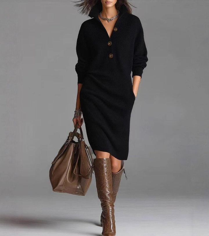 Model in a chic black knit dress with buttons, holding a brown bag. Studio setting with a neutral background.