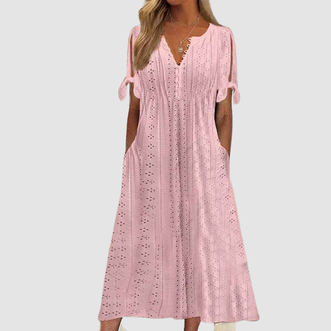Pink elegant casual dress with eyelet details and tie sleeves, presented in a studio setting.