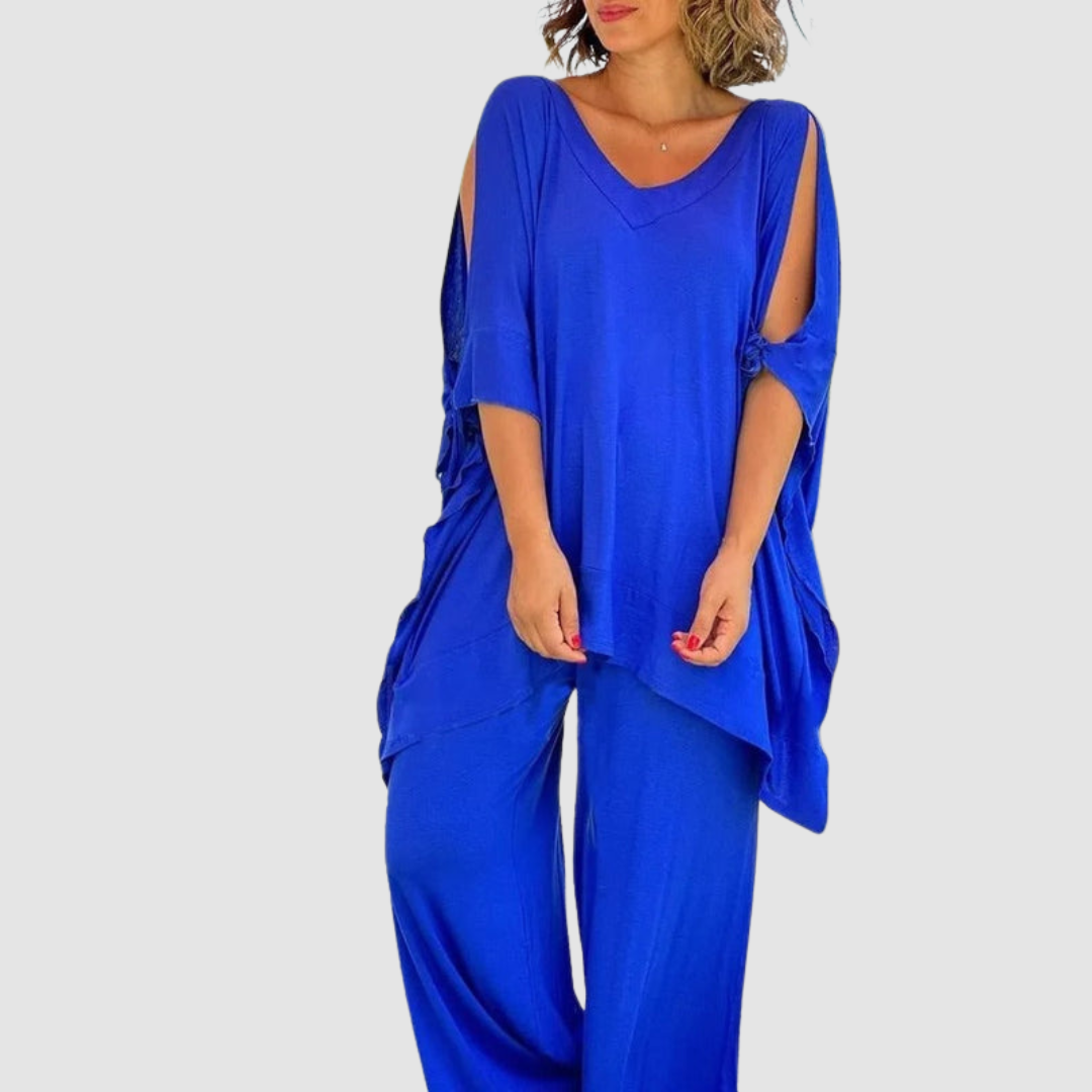 Woman wearing a vibrant blue relaxed style set with loose top and wide-leg pants, in a studio setting.