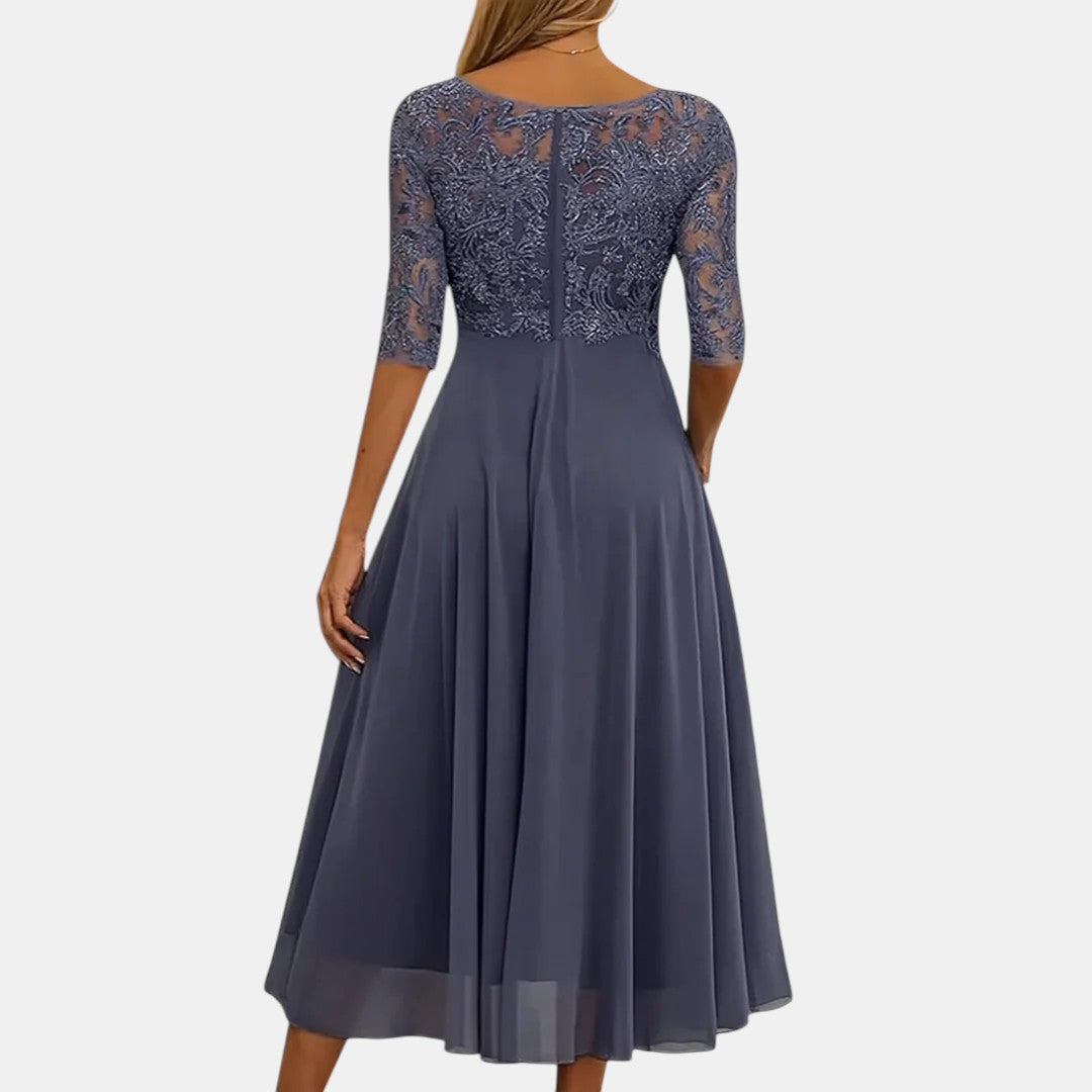 Back view of elegant dark blue dress with lace bodice, studio background.
