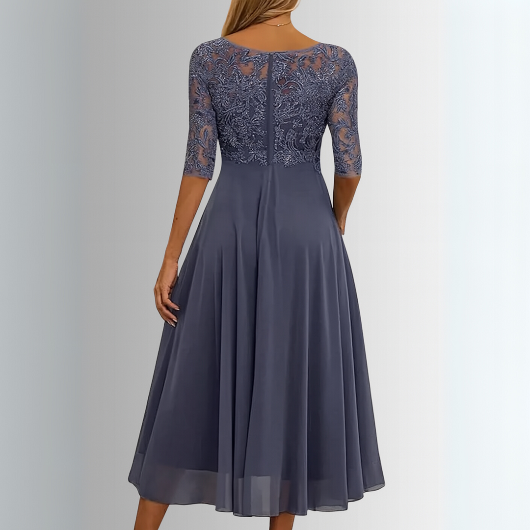 Back view of an elegant blue lace dress with sheer sleeves in a studio setting.