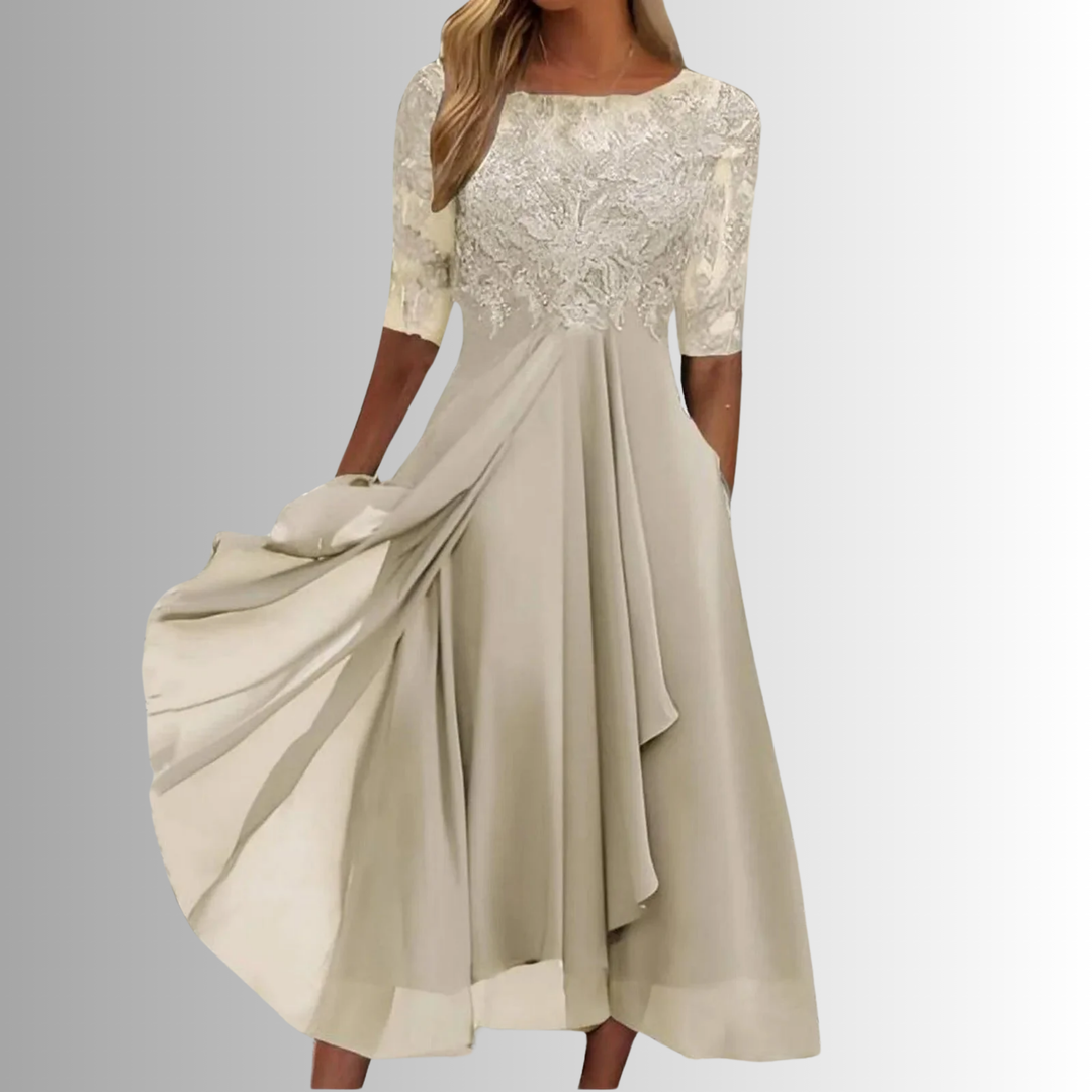 Elegant beige lace dress with sheer sleeves in a studio setting.