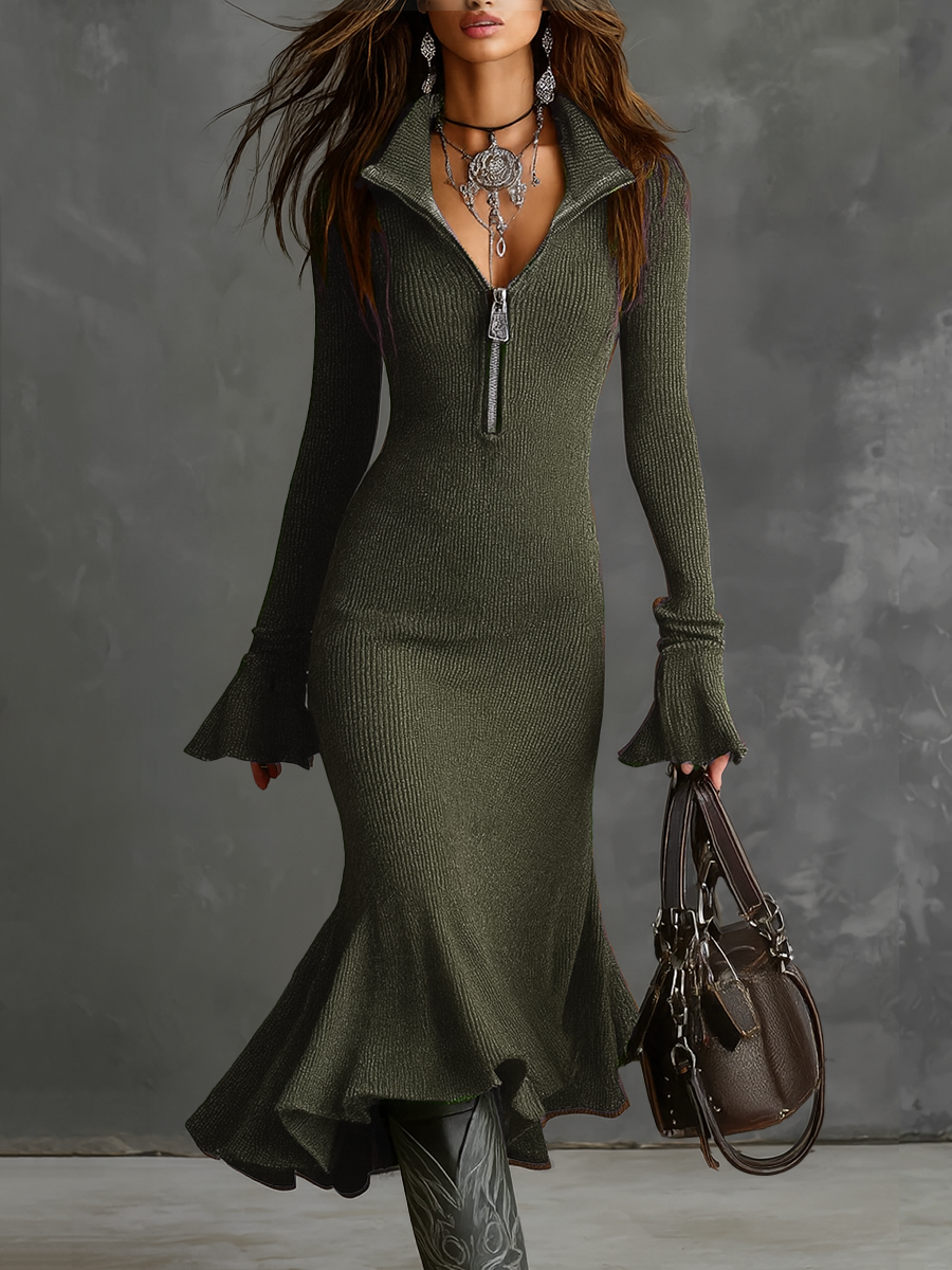 Retro zip neck knit midi dress in green with flared cuffs and ruffled hem, accompanied by a handbag. Studio background.