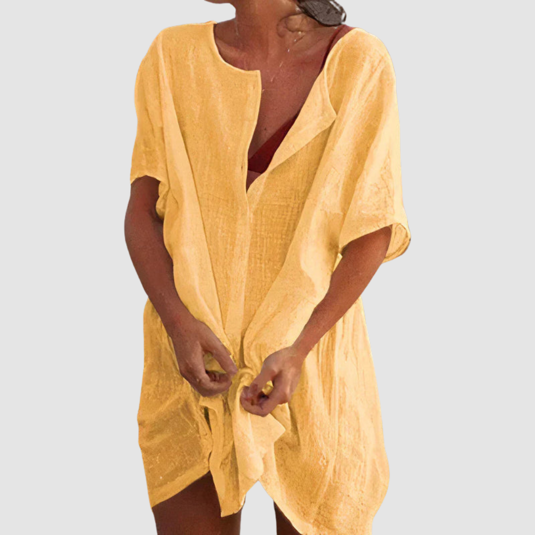 Yellow loose fit dress with short sleeves and textured fabric, worn by person with untied front, studio background.