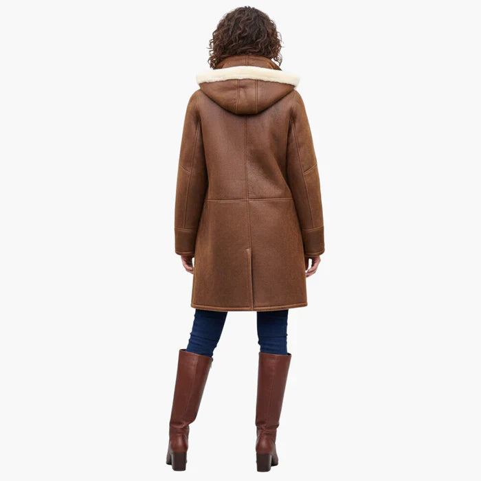 Back view of brown coat with hood, worn by a person. Styled with jeans and brown boots. White background.