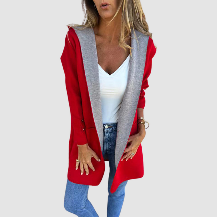 Red and gray colorblock hooded jacket worn over white top and jeans in a studio setting.