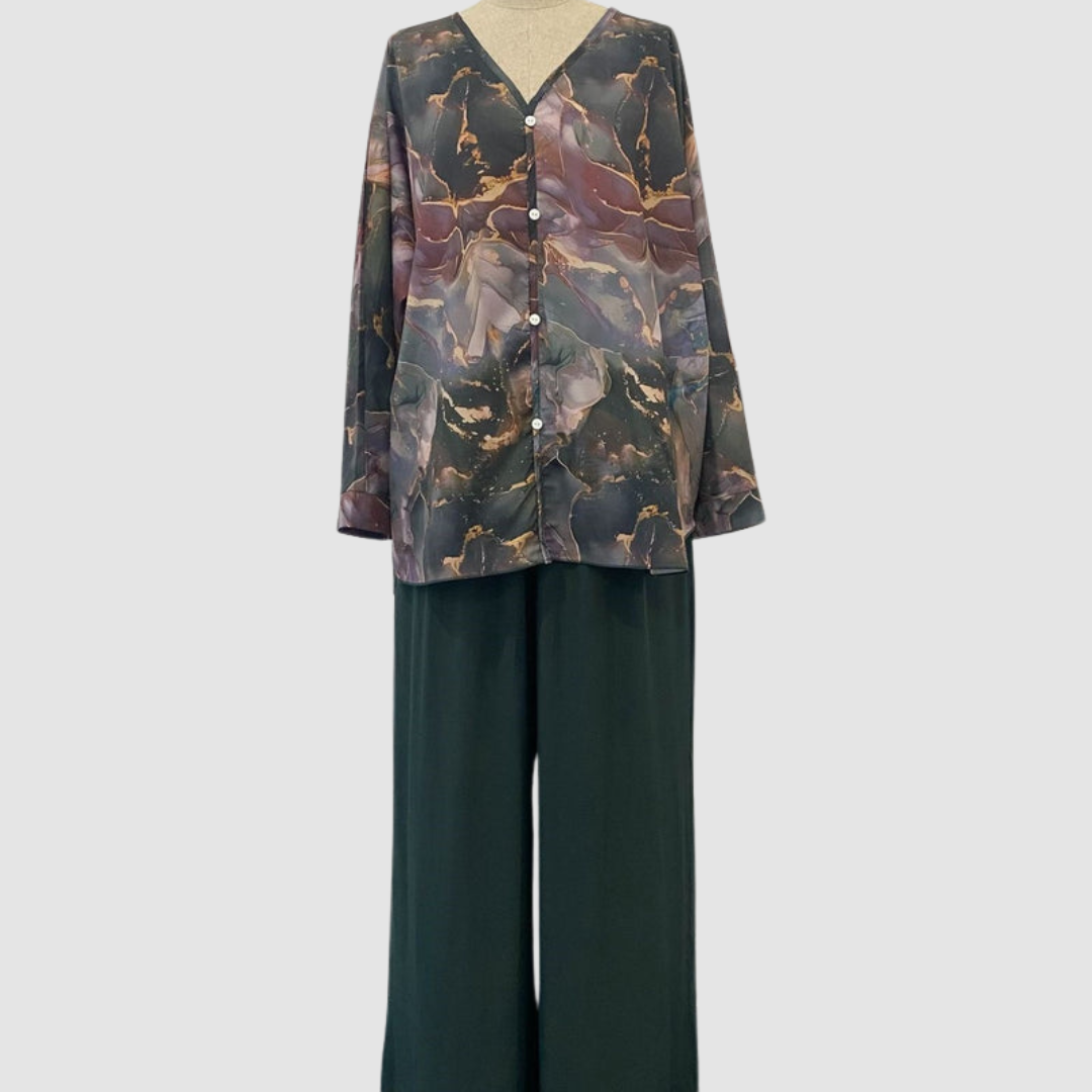 Mannequin displaying an elegant printed two-piece set with a button-up top and flowing pants, set against a plain background.