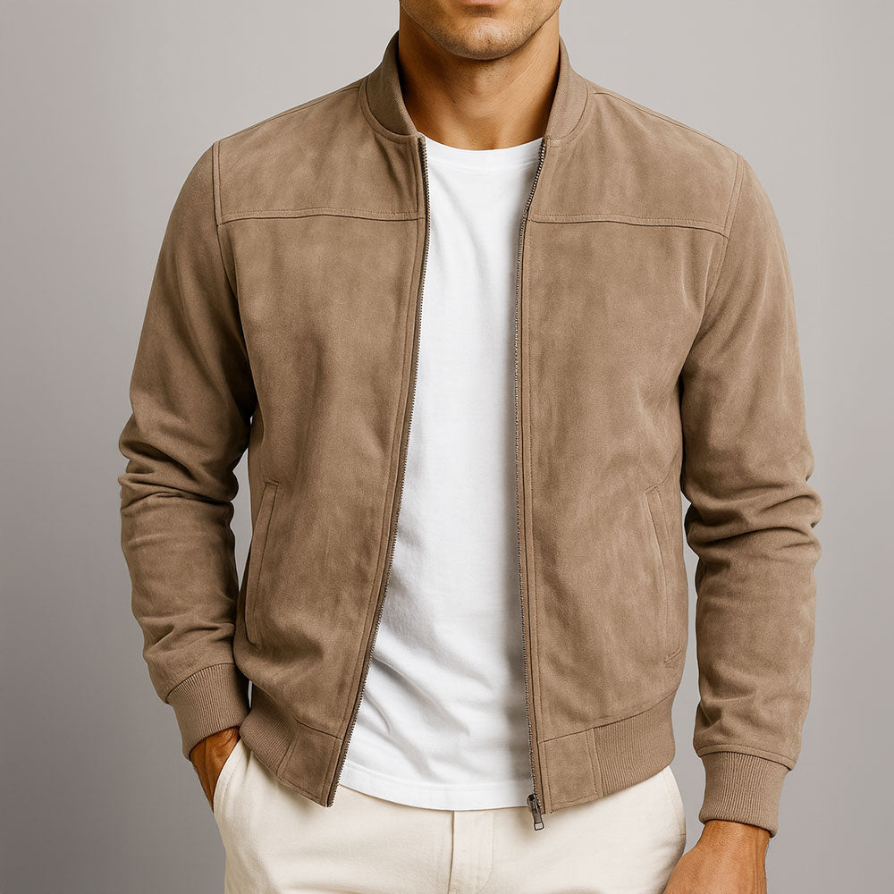 Man wearing a tan urban classic jacket, white shirt, and beige pants against a neutral background.