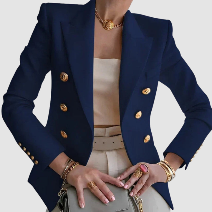 Elegant navy blazer with gold buttons, worn over a neutral outfit. Gold jewelry adds sophistication in a studio setting.