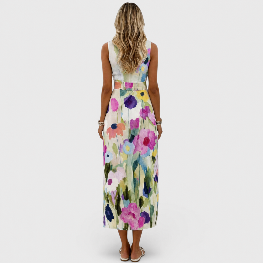 Back view of woman in floral midi dress featuring colorful flower design in studio setting.