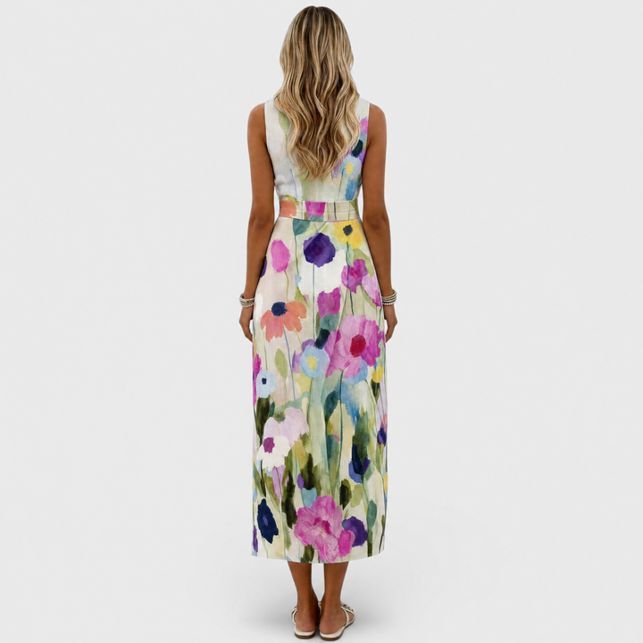 Back view of woman in floral midi dress featuring colorful flower design in studio setting.