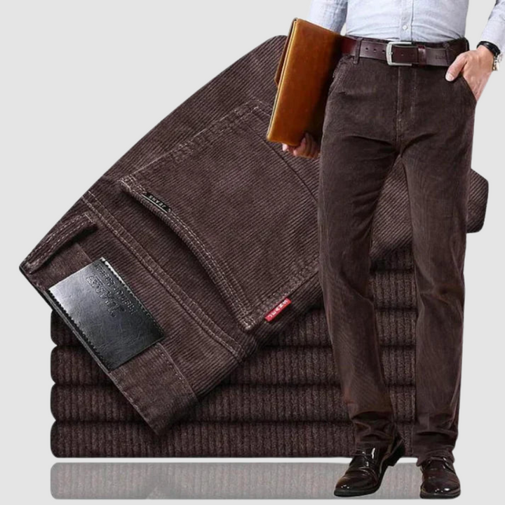 Dark brown corduroy trousers with a refined look, featured in a minimal backdrop to accentuate texture.