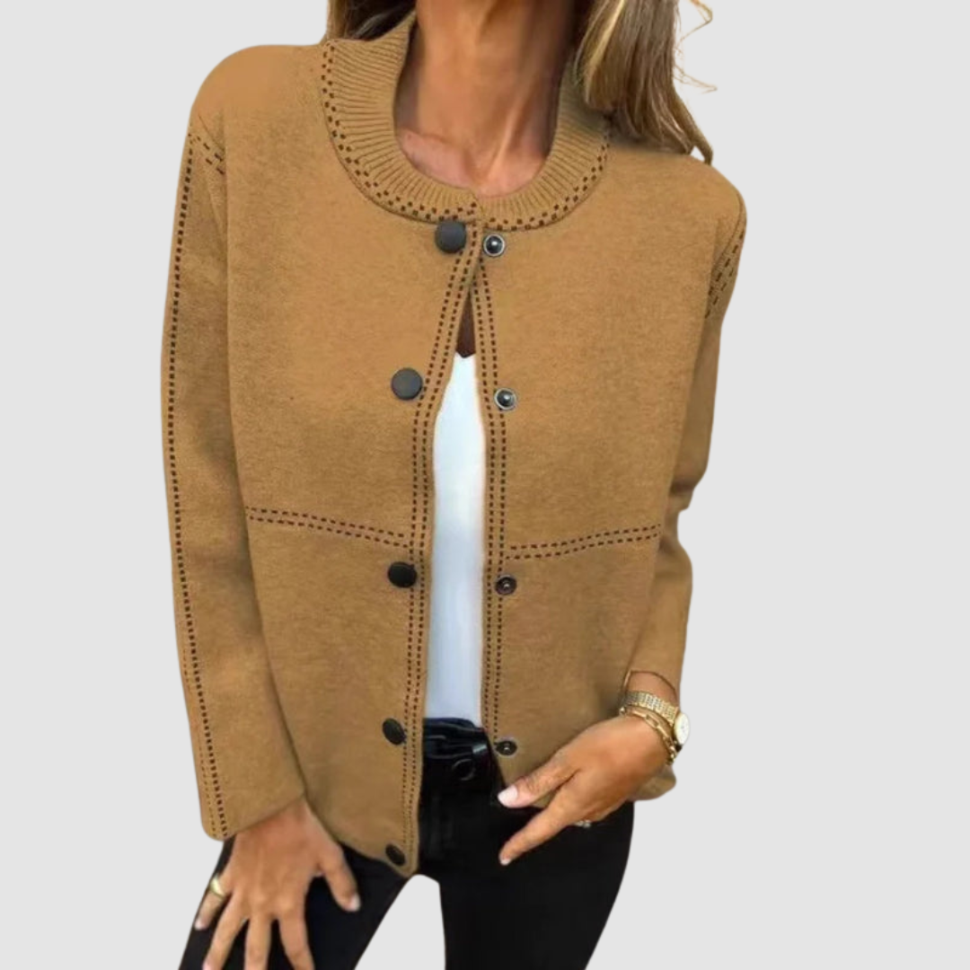 Brown jacket with round collar, button closure, worn over white top and black pants in a studio setting.