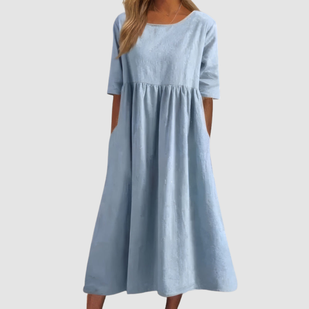 Light blue breezy dress with elbow-length sleeves in a studio setting.