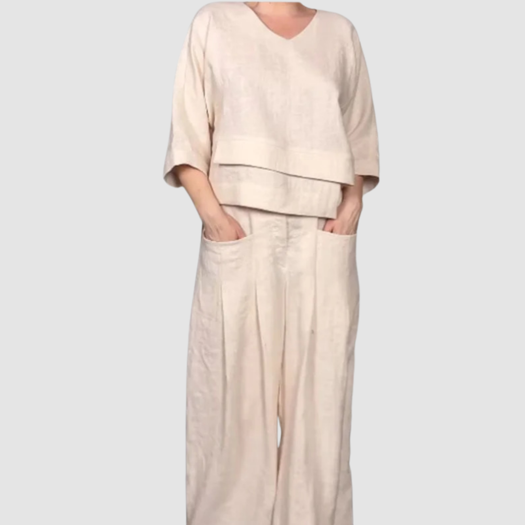 Beige relaxed 2-piece set with V-neck top and wide-leg pants featuring pockets, studio background.
