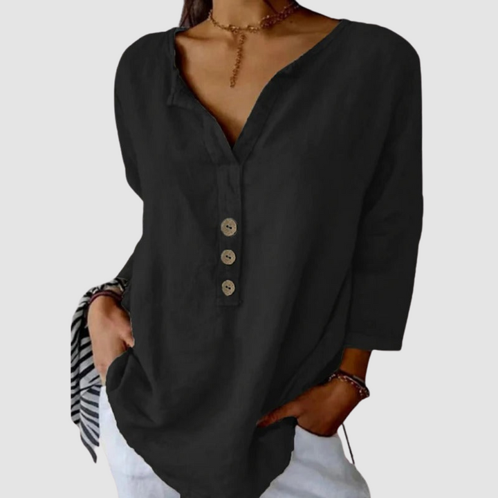 Casual black blouse with button detail, worn by a model with a choker, against a plain background.