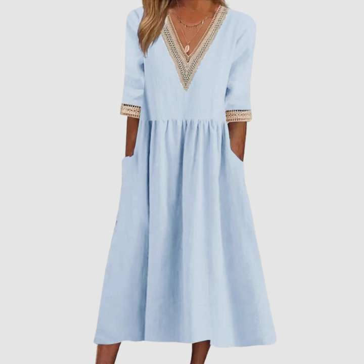 Light blue mid-length dress with crochet trim neckline and sleeves, styled in a studio on a light gray background.