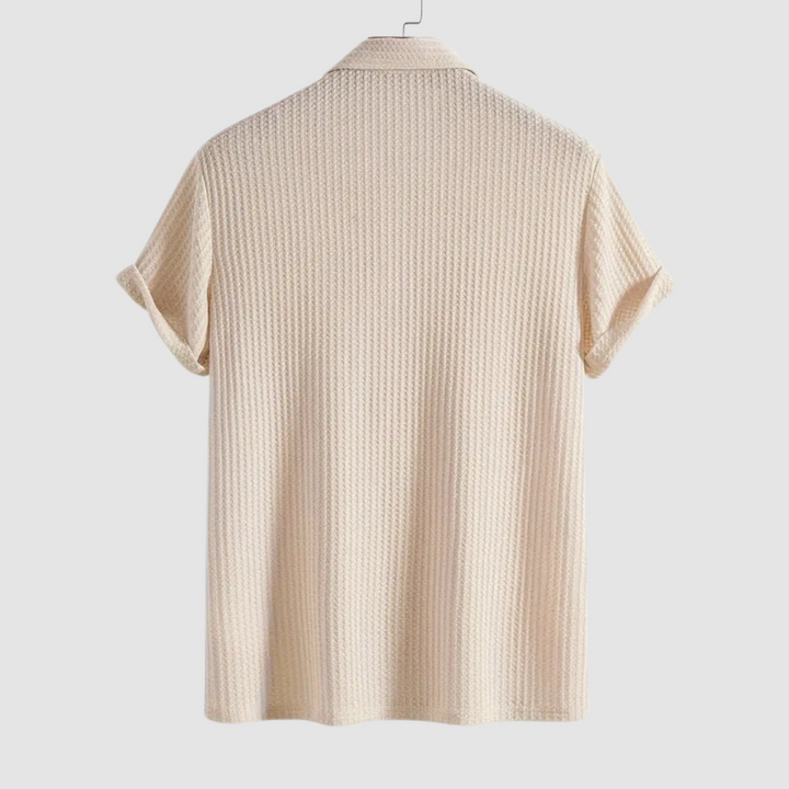 Back view of light cream textured polo shirt on a hanger against a plain light gray background.