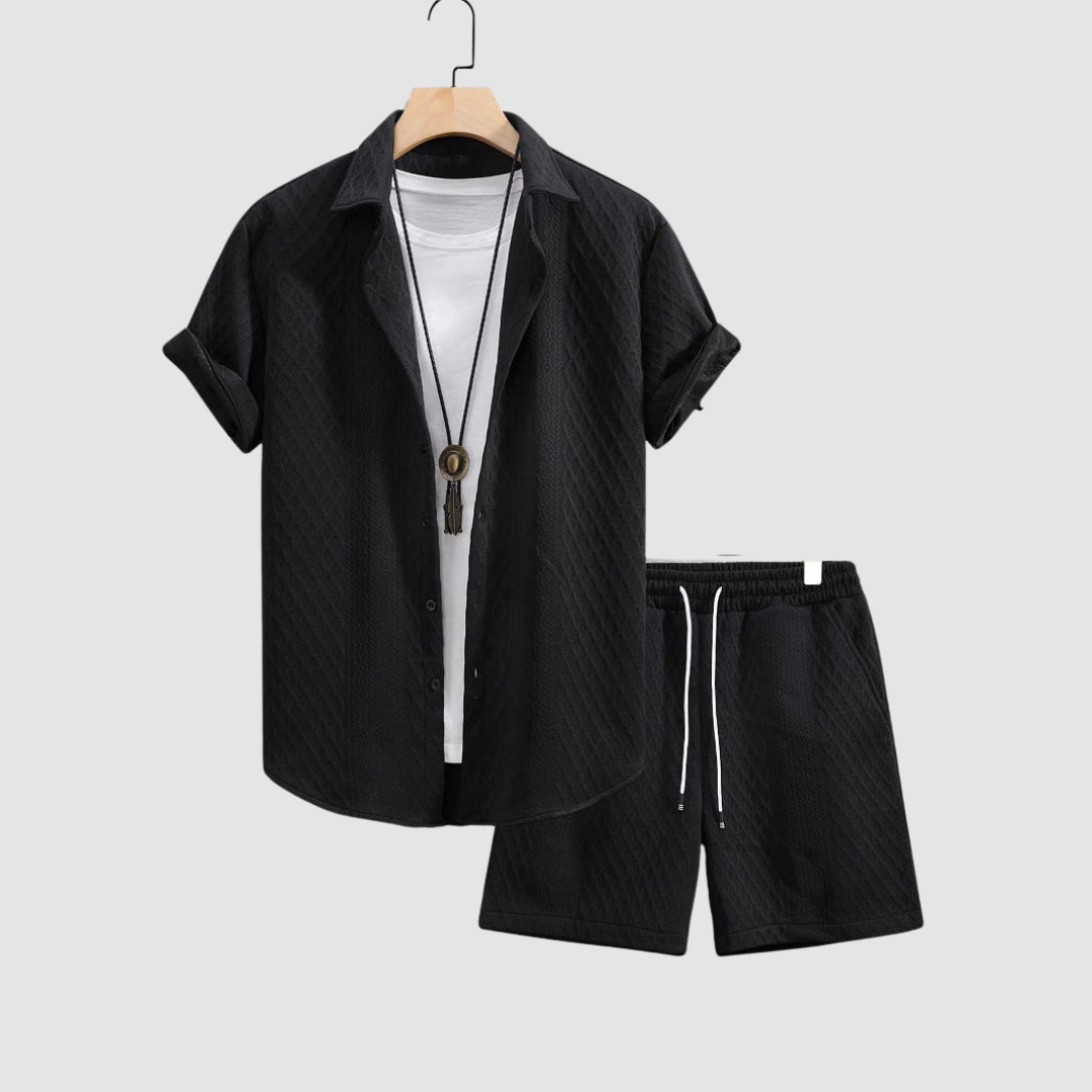 Black short-sleeve shirt and shorts on hangers, with a white T-shirt underneath, against a light gray background.