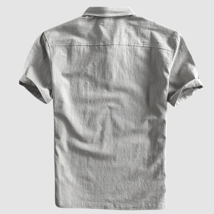 Back view of light gray short-sleeve polo shirt, displayed on a minimalist light gray background.