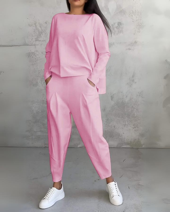 Pink lounge set with comfortable fit displayed in a gray textured studio backdrop.