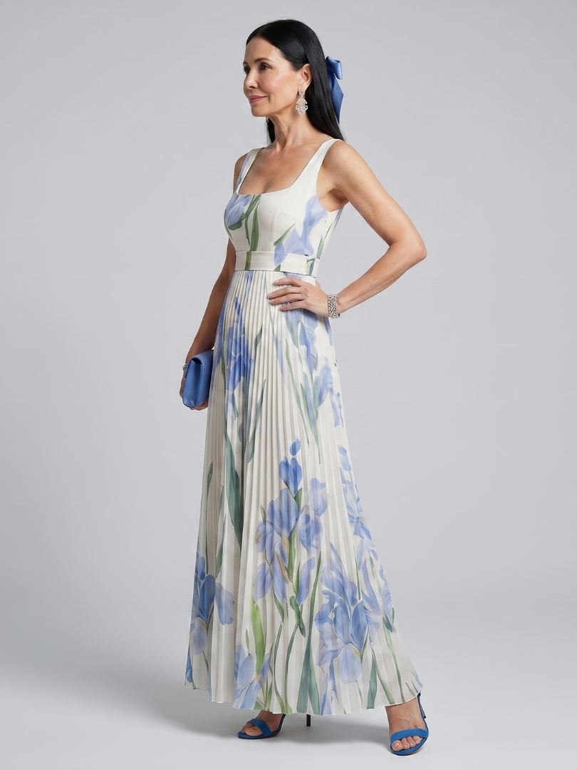 Side view of woman in floral print midi dress, holding clutch in studio.