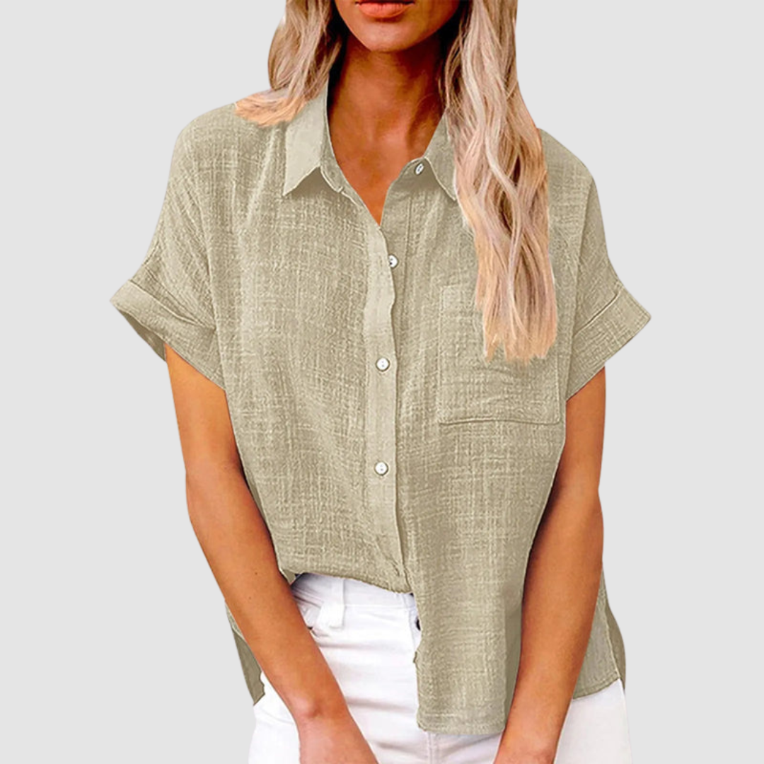 Beige casual blouse with short sleeves and front buttons, worn in white jeans. Studio background.