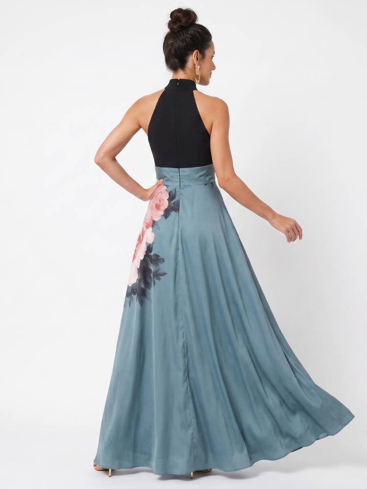 Back view of model in a maxi dress with black halter bodice and floral skirt, studio setting.