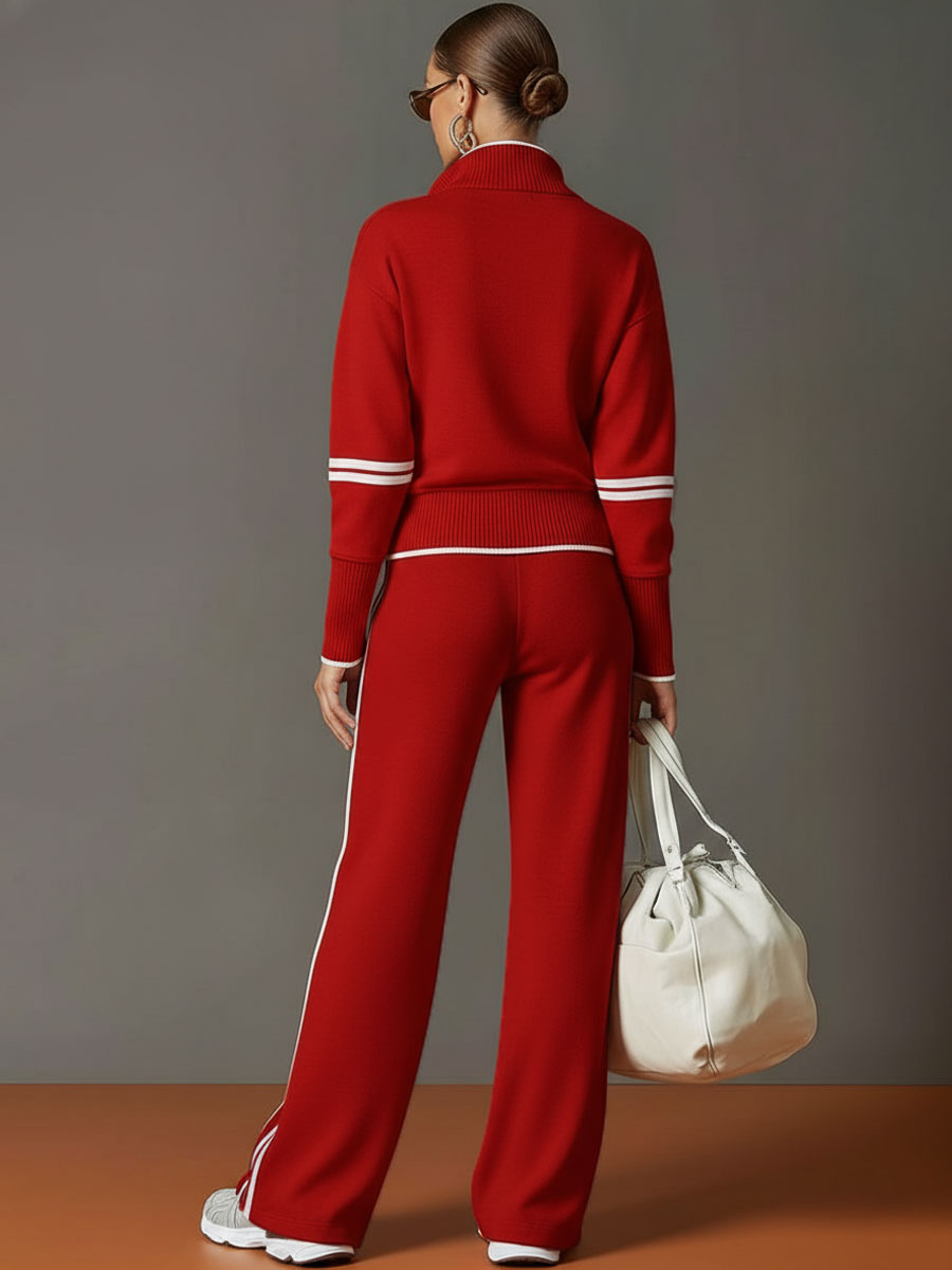 Back view of matching lounge set in red with contrast stripes, paired with white sneakers and a bag in a studio setting.