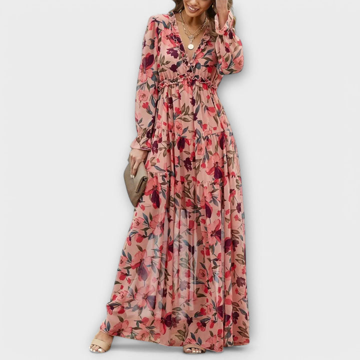 Floral maxi dress with long sleeves and v-neck, worn by model in a neutral studio setting.