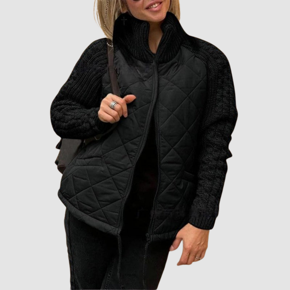 Black quilted jacket with knit sleeves, worn by a person in casual setting.