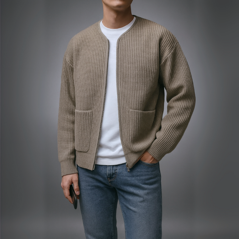 Model wearing a light brown knit zip cardigan with white shirt and jeans in a studio setting.