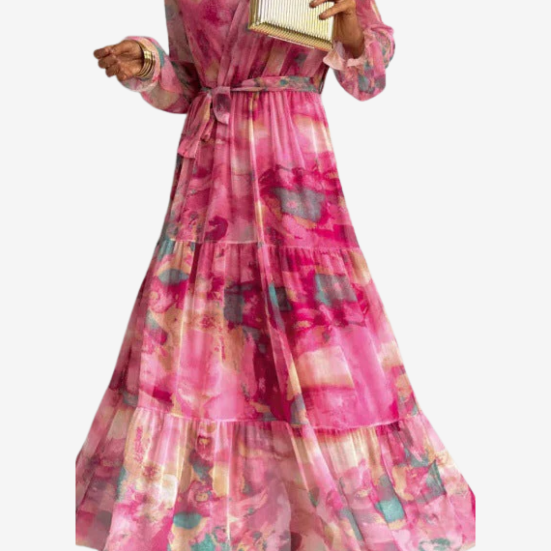 Flowing pink dress with bold patterns and belted waist. Model&