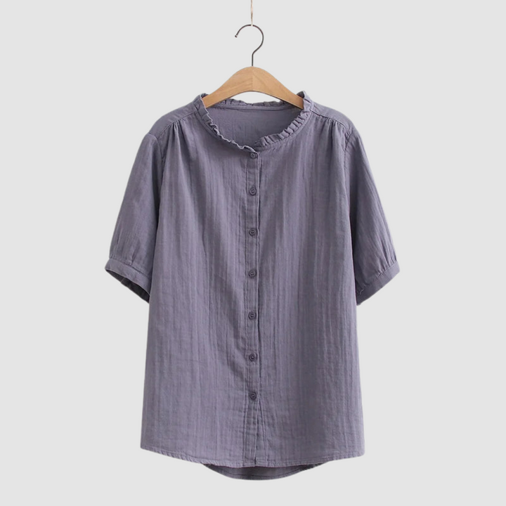 Deep lavender button-up shirt with ruffled collar on wooden hanger, studio background.