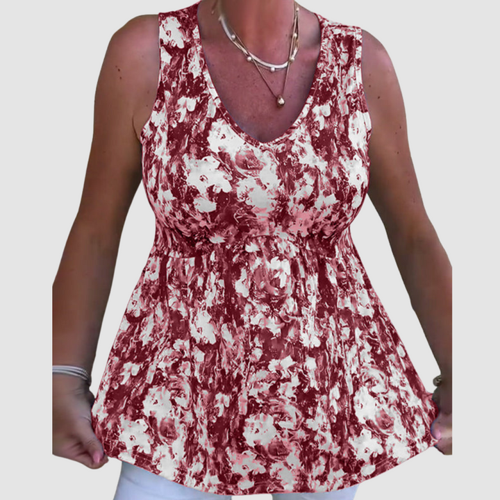 Close-up of woman wearing a red and white abstract pattern sleeveless top in a studio setting.