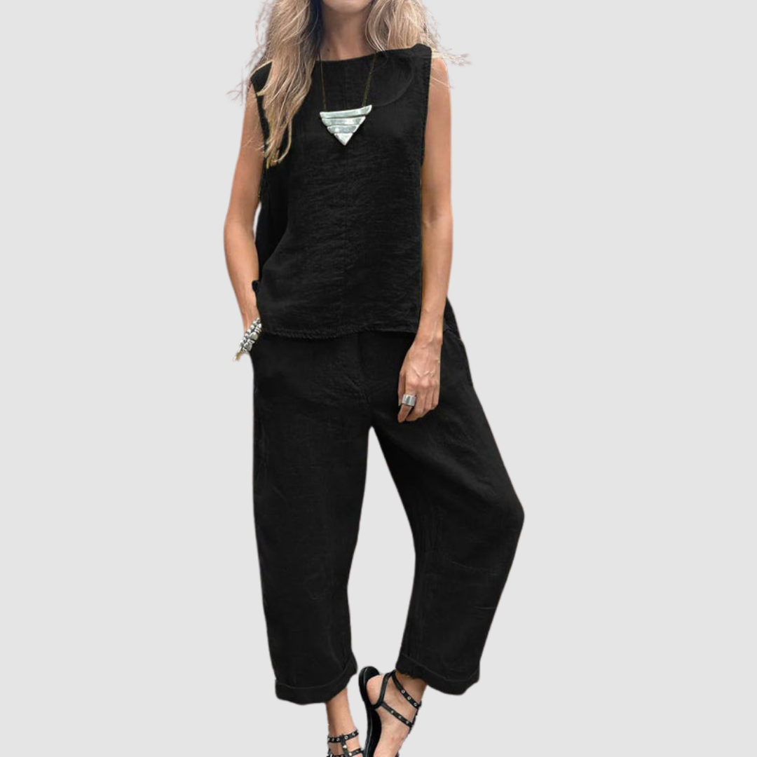 Classic black two-piece summer set with sleeveless top and loose pants, worn by model, gray background.