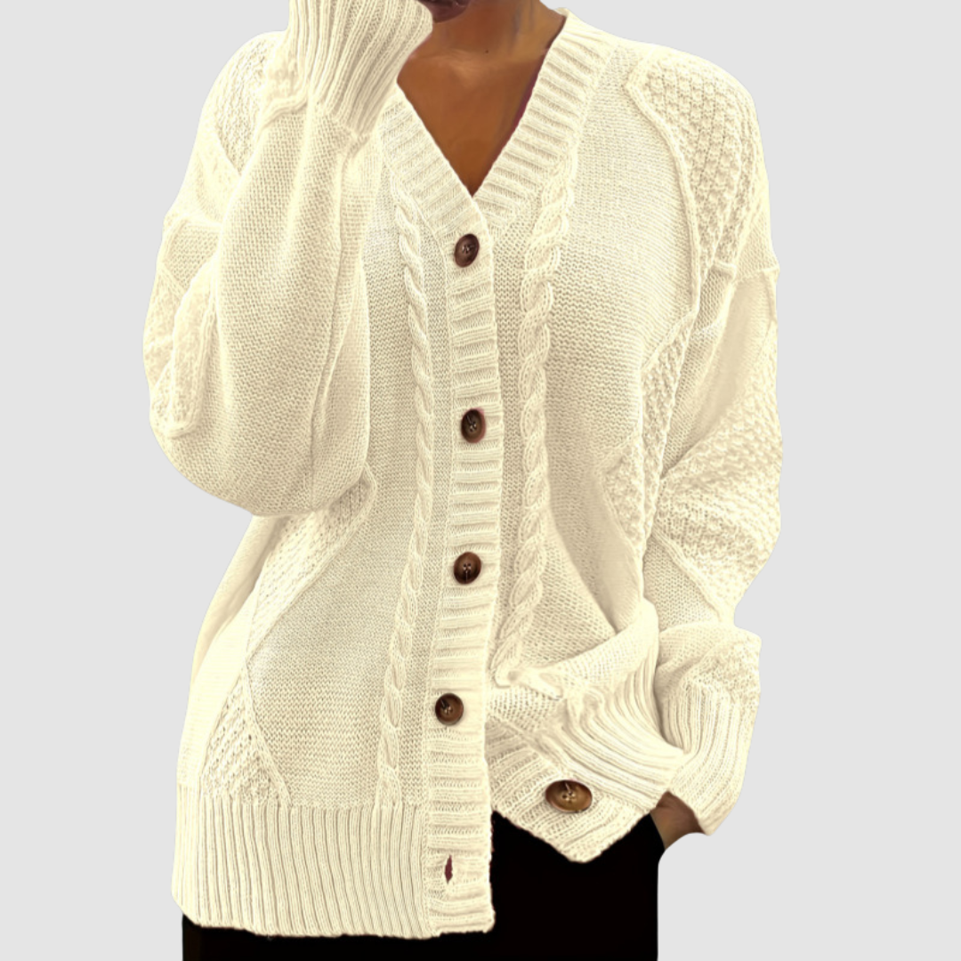 Cream button-up sweater with textured patterns, worn by a model; studio background.