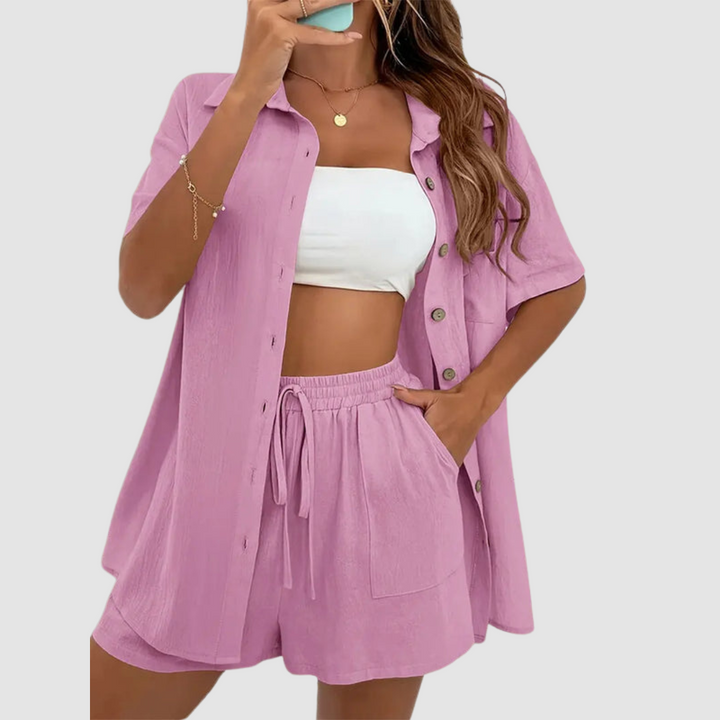 Woman in pink two-piece set with button-up top and drawstring shorts, white tube top, studio background.