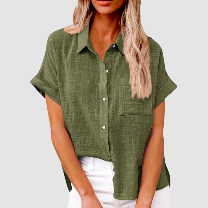 Olive green casual blouse with short sleeves and front buttons, worn in white jeans. Studio background.