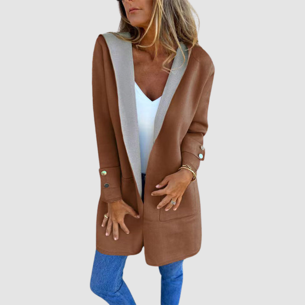 Brown and gray colorblock hooded jacket worn over white top and jeans in a studio setting.