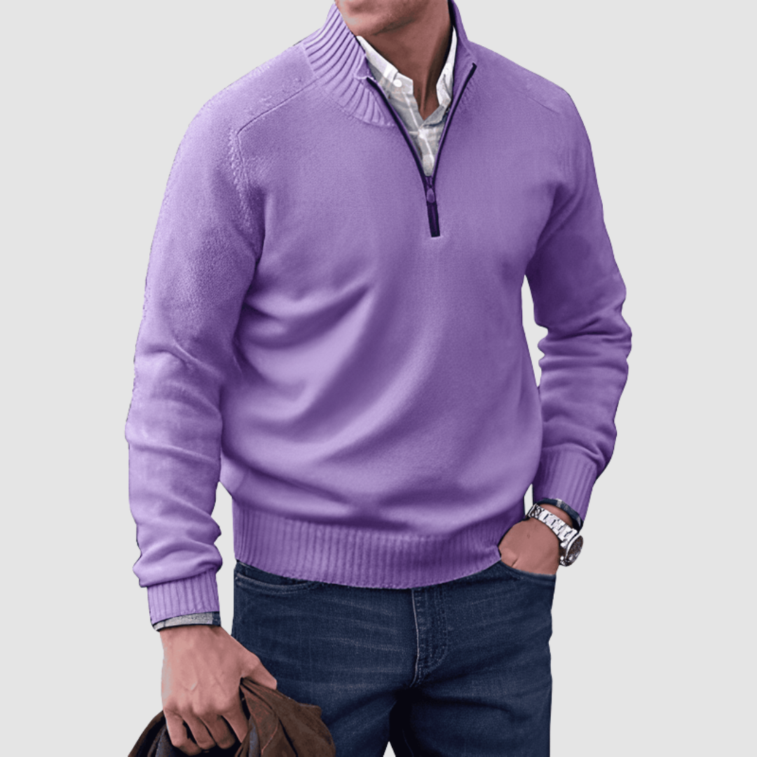 Model in purple zip pullover with ribbed collar and cuffs, holding a jacket. Paired with jeans, set against a plain background.