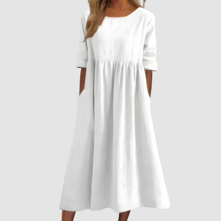 White breezy dress with elbow-length sleeves in a studio setting.