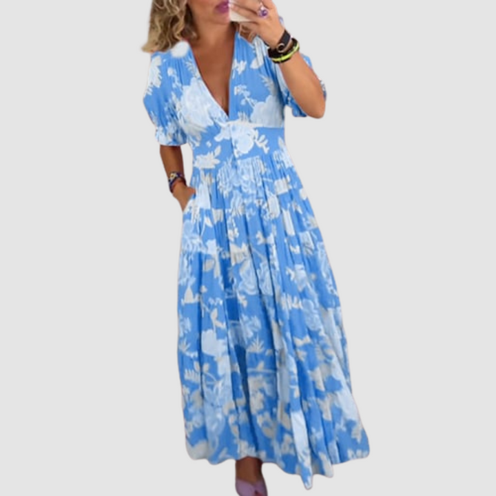 Blue floral long dress modeled indoors, featuring short sleeves and a flowy, comfortable design.