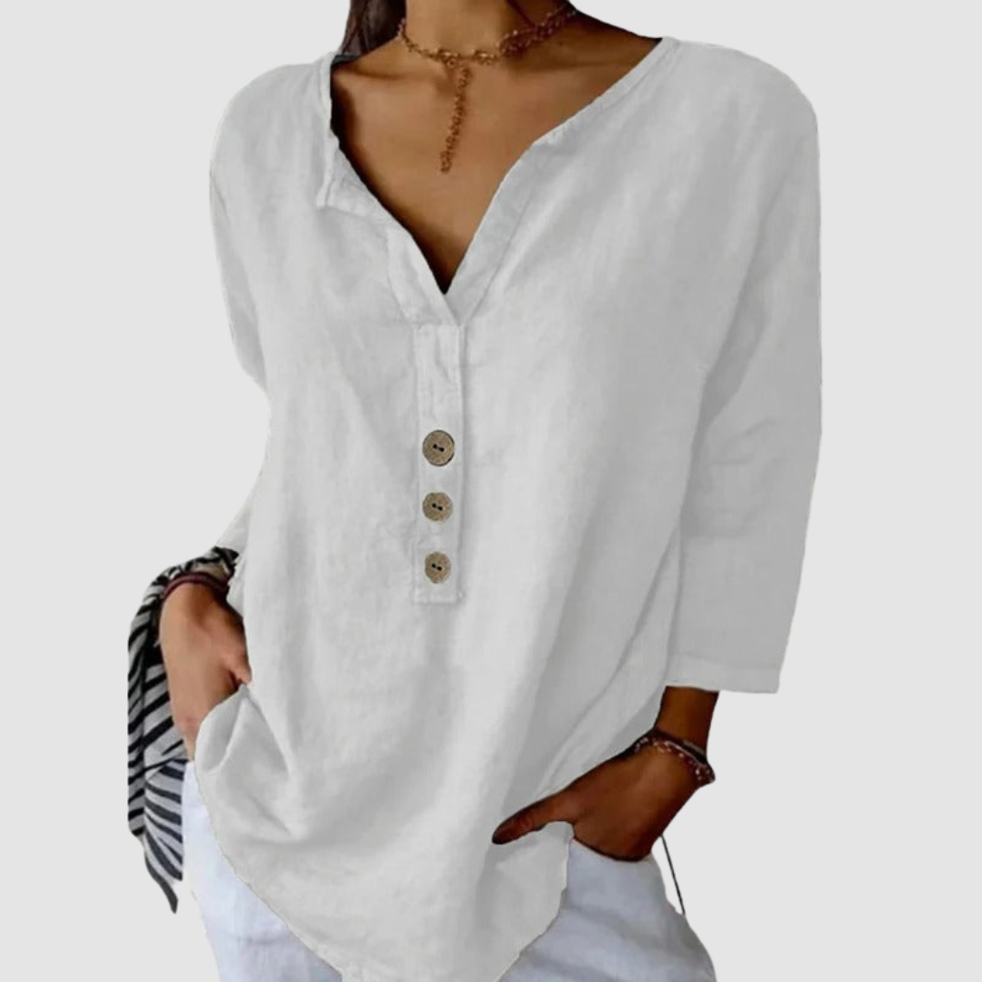 Casual white blouse with button detail, worn by a model with a choker, against a plain background.