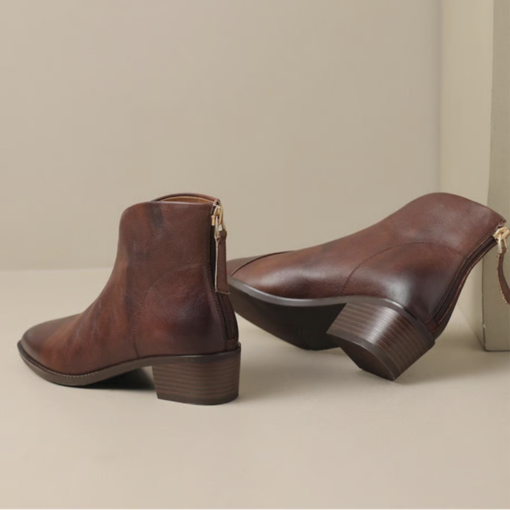 Pair of brown ankle boots with block heels, displayed in an indoor setting with a light background.