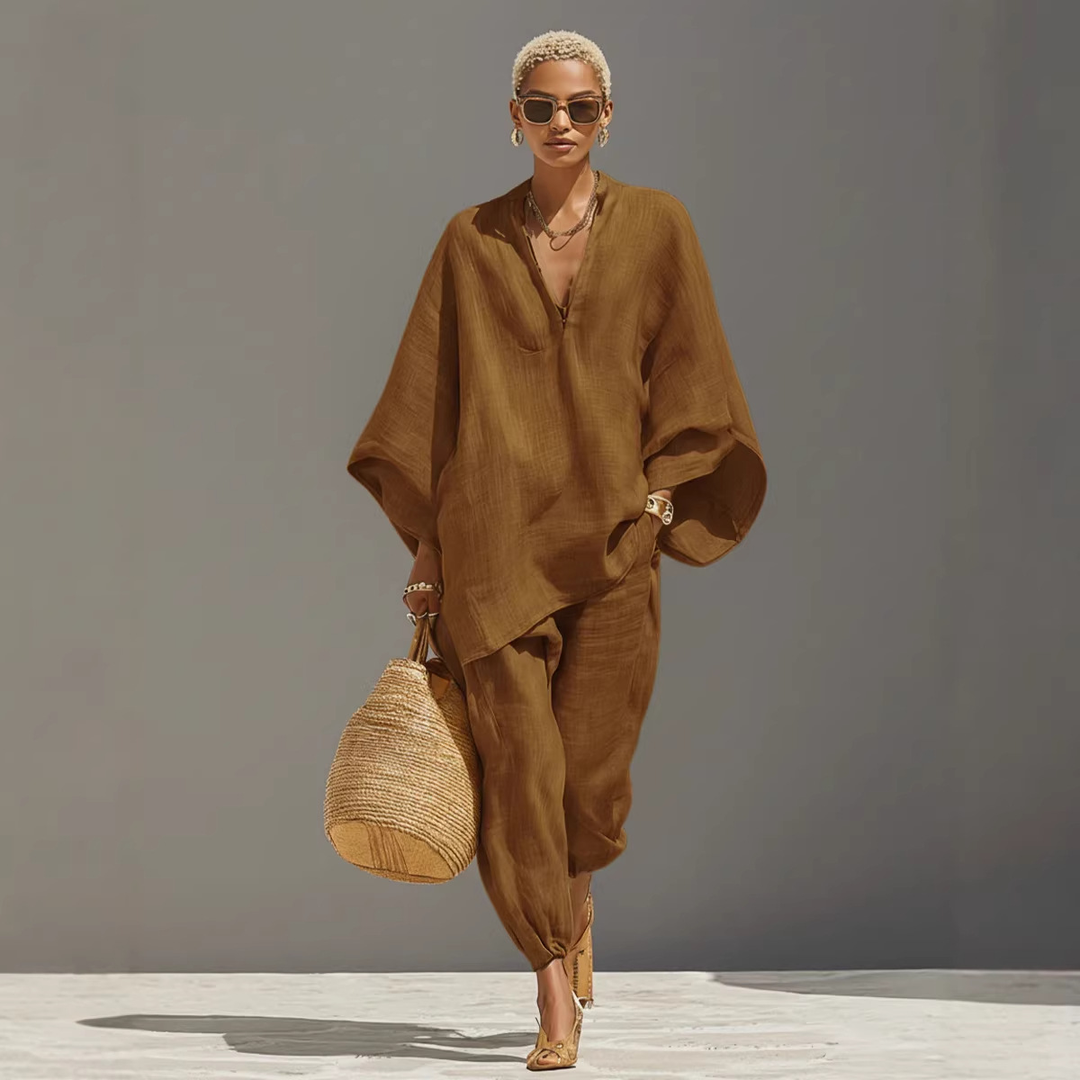 Model wearing brown batwing sleeve V-neck lounge set with straw bag, studio background.