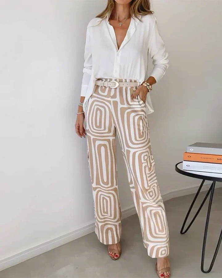 Elegant two-piece ensemble with a white blouse and beige geometric-patterned pants. Photographed in a minimalist indoor setting.