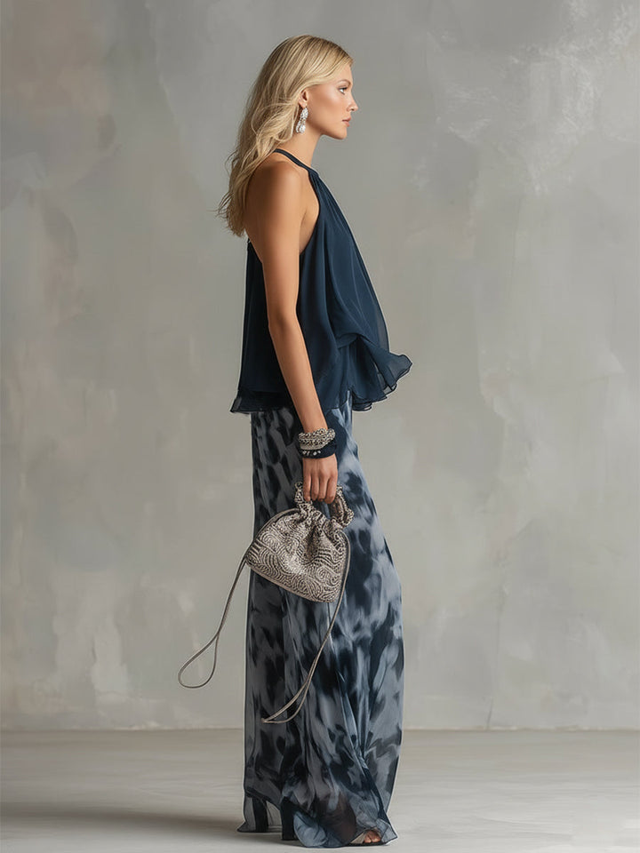 Side view of an elegant halter neck top and wide-leg patterned pants. Includes a delicate handbag. Studio setting.