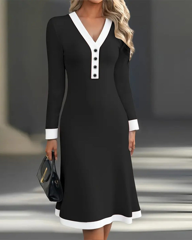 Black long-sleeve dress with white collar and cuffs, accessorized with a black handbag, in a modern indoor setting.